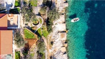 Une maison en bord de mer dans une baie fantastique de l'île de Korcula, avec amarrage de bateau devant 